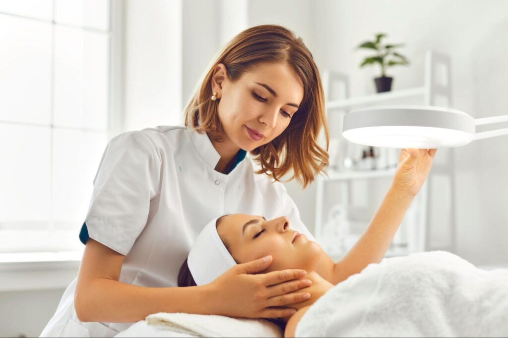 A skincare expert assessing a client’s skin type to recommend a personalized skincare treatment plan.