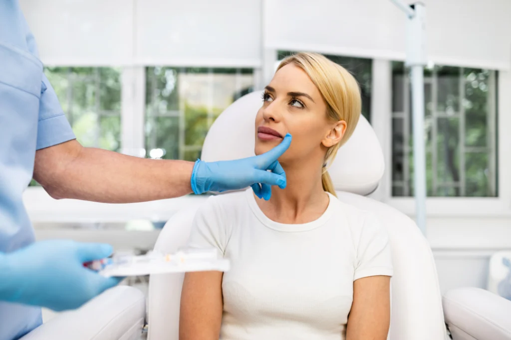 A practitioner examining a patient's face as part of a personalized aesthetics consultation.